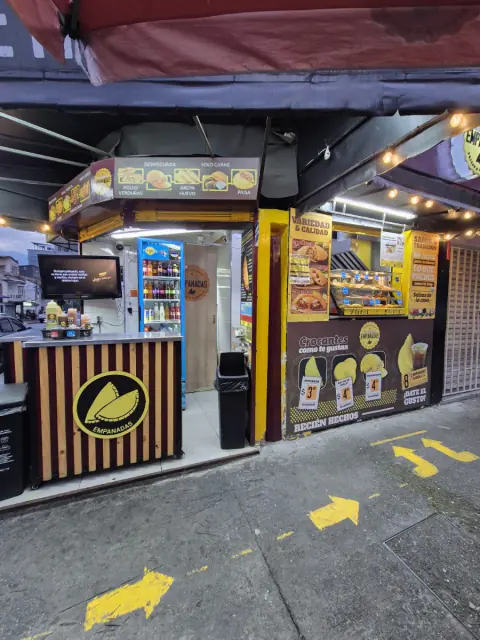 Local de Empanadas la Tradición de noche, con luces y avisos