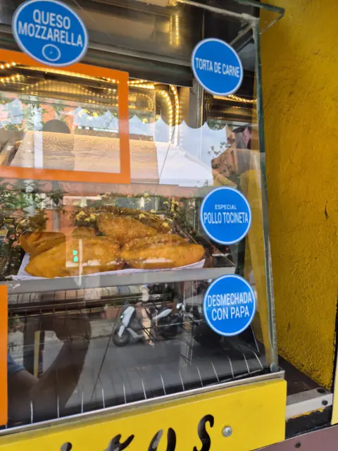 Vitrina con etiquetas de sabores: queso mozzarella, torta de carne, pollo con tocineta y desmechada con papa